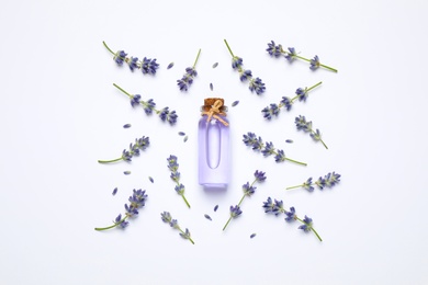 Composition with lavender flowers and natural essential oil on white background, top view