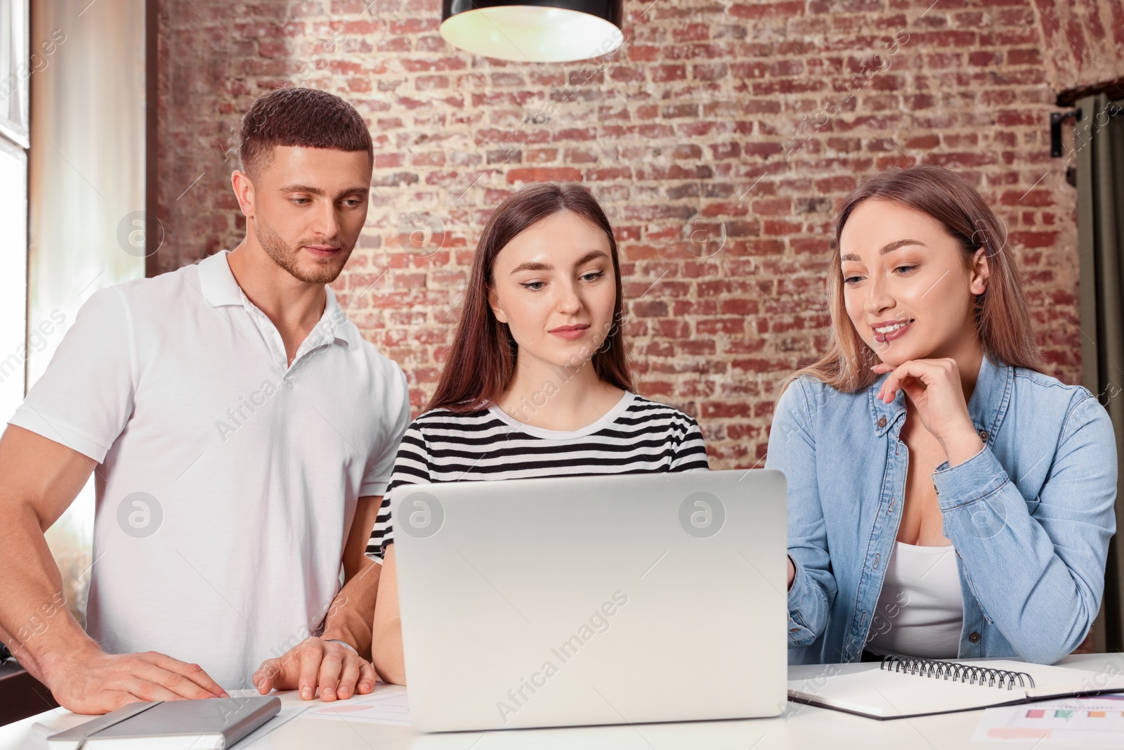 Photo of Team of employees working together in office