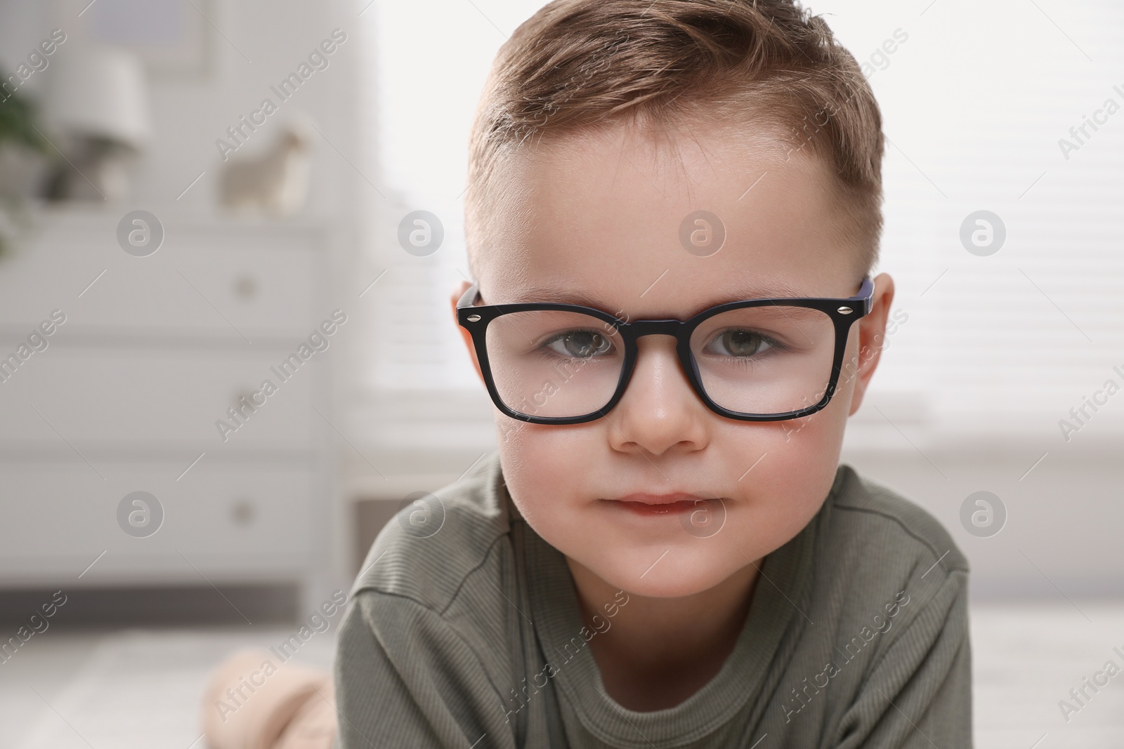 Photo of Cute little boy in glasses at home. Space for text