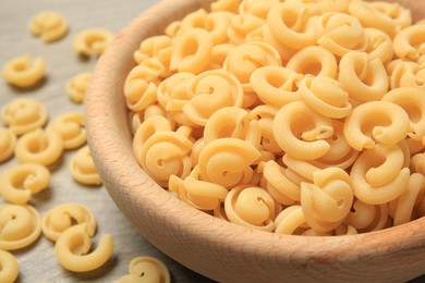 Raw dischi volanti pasta in bowl on table, closeup