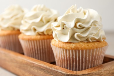 Photo of Tasty cupcakes with vanilla cream on table, closeup