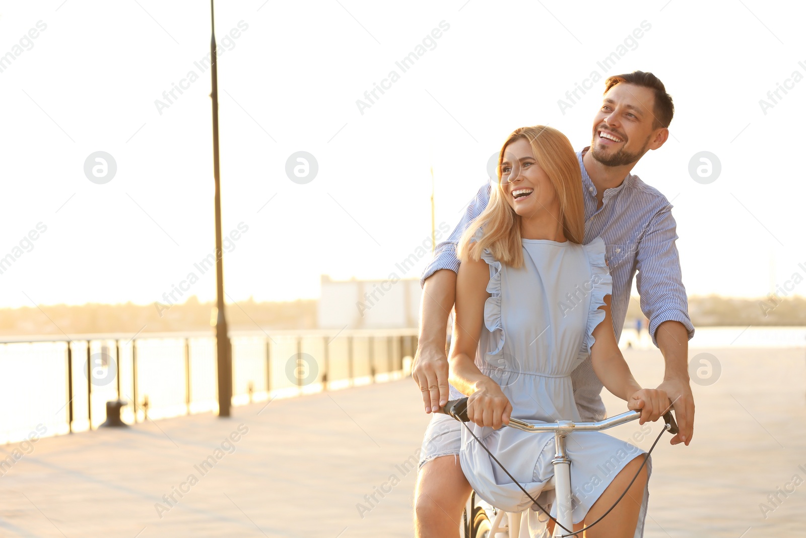 Photo of Happy couple riding bicycle outdoors on summer day