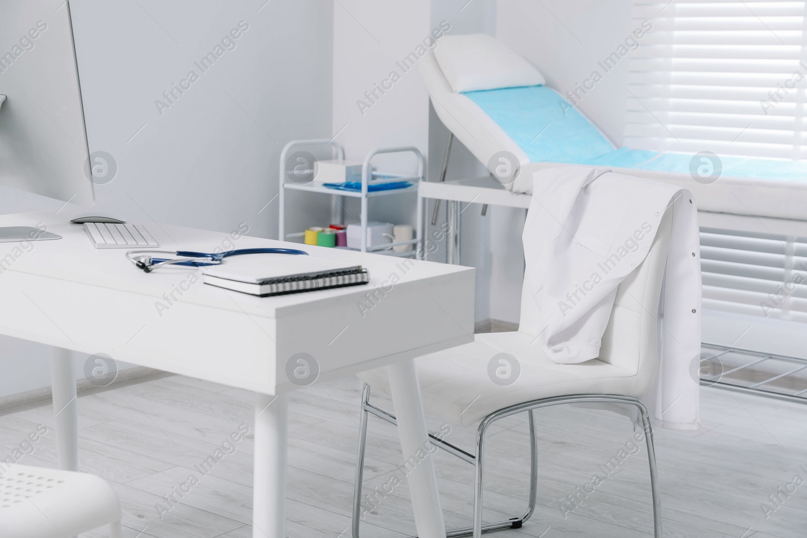 Photo of White doctor's gown hanging on chair in clinic