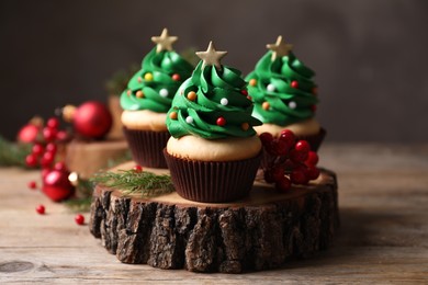 Photo of Christmas tree shaped cupcakes on wooden stand, closeup
