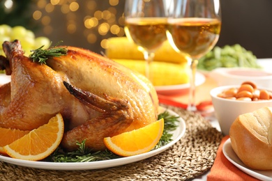 Photo of Delicious roasted turkey with garnish on dinner table