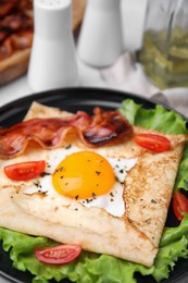 Photo of Delicious crepe with egg on table, closeup. Breton galette