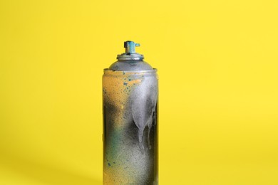 Photo of One spray paint can on yellow background