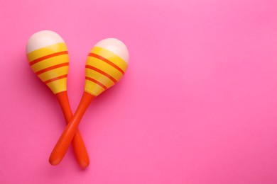 Colorful maracas on pink background, flat lay with space for text. Musical instrument