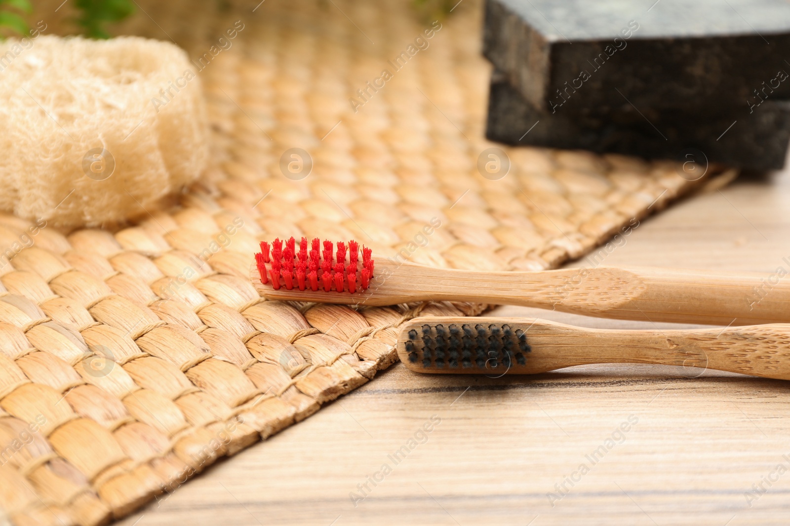 Photo of Natural toothbrushes made with bamboo on wooden table