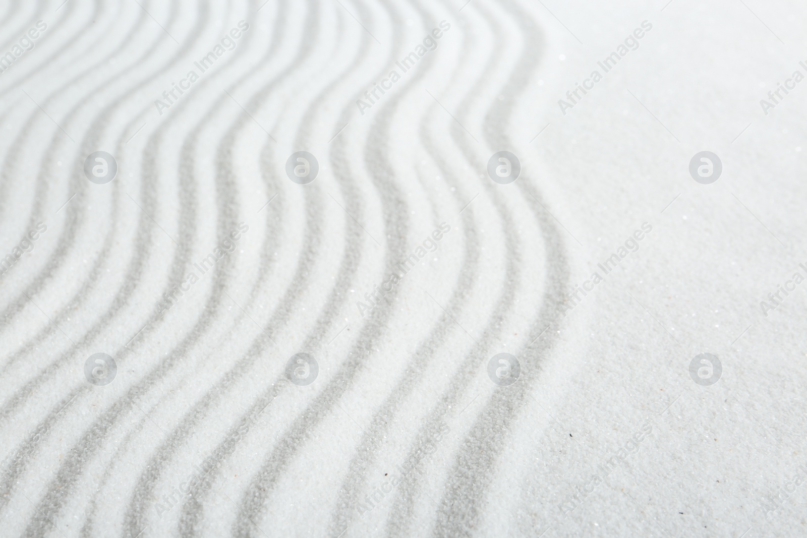 Photo of Zen rock garden. Wave pattern on white sand, closeup