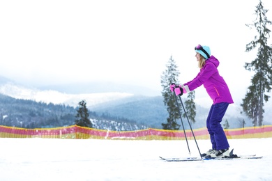 Photo of Female skier on slope at resort, space for text. Winter vacation