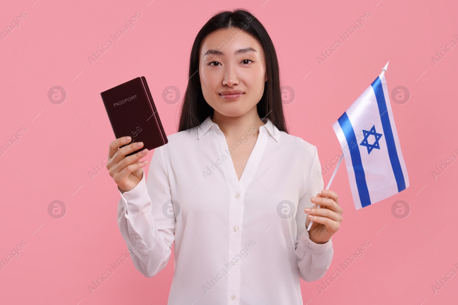 Photo of Immigration to Israel. Woman with passport and flag on pink background