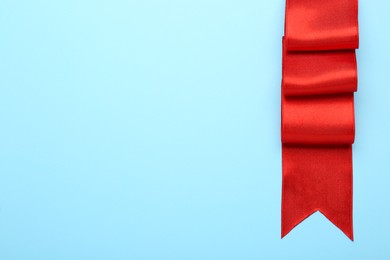 Photo of Beautiful red ribbon on light background, top view. Space for text