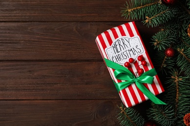 Christmas composition with gift box and festive decor on wooden table, flat lay. Space for text