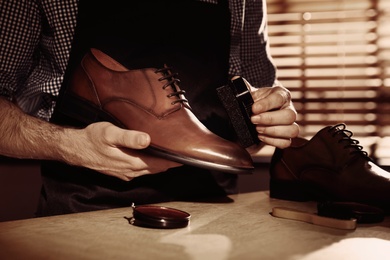 Image of Man taking care of shoes in workshop, closeup