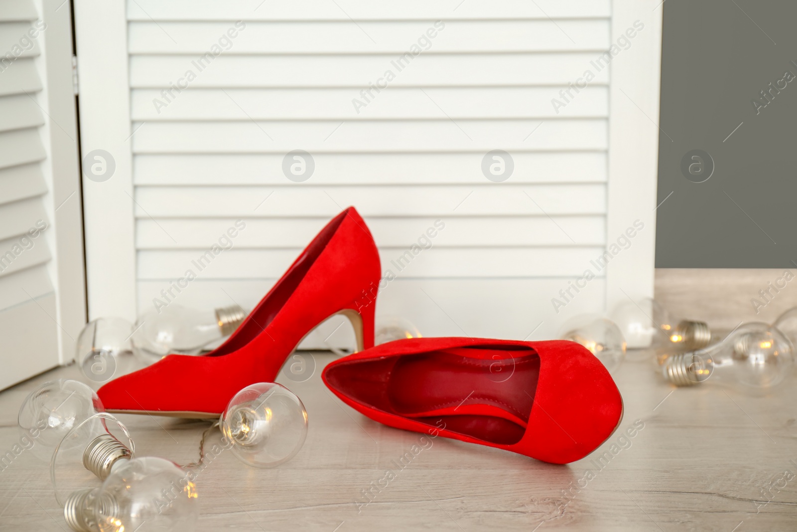 Photo of Elegant female shoes on wooden floor