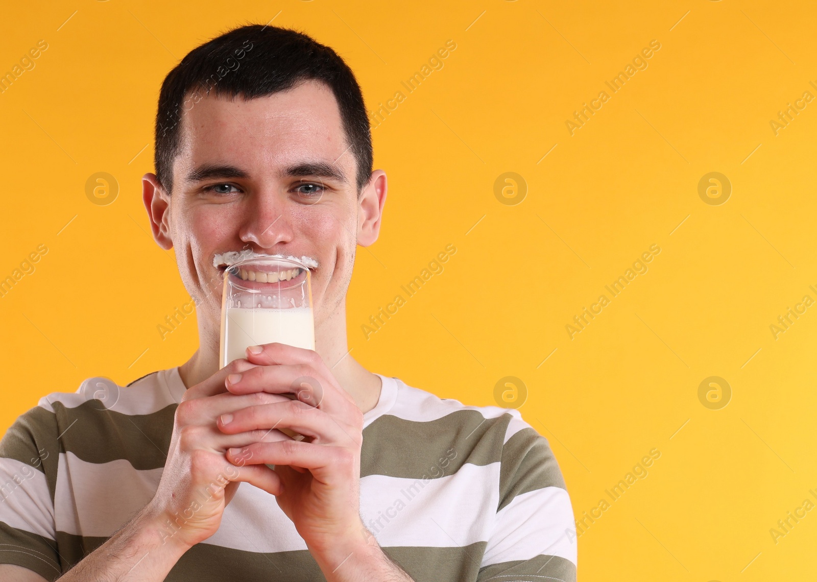 Photo of Milk mustache left after dairy product. Man drinking milk on orange background, space for text