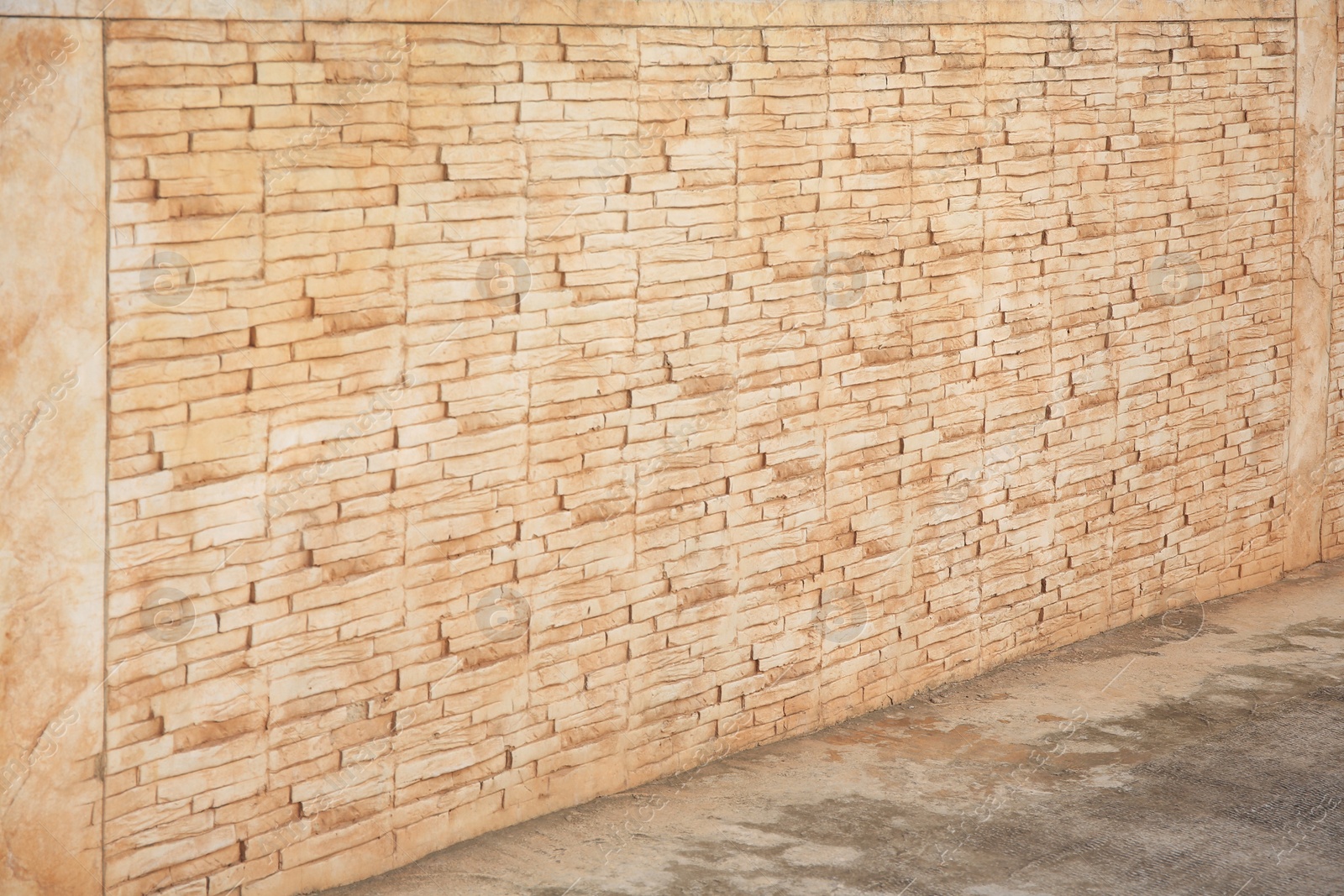 Photo of Beautiful old brick wall and concrete sidewalk outdoors