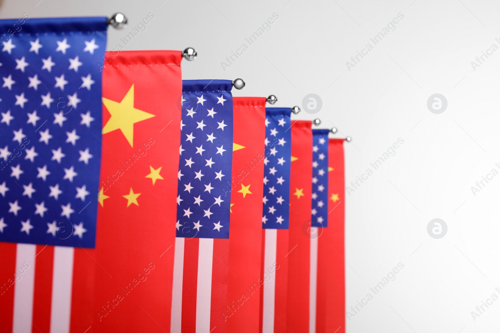 Photo of USA and China flags on white background, closeup. International relations