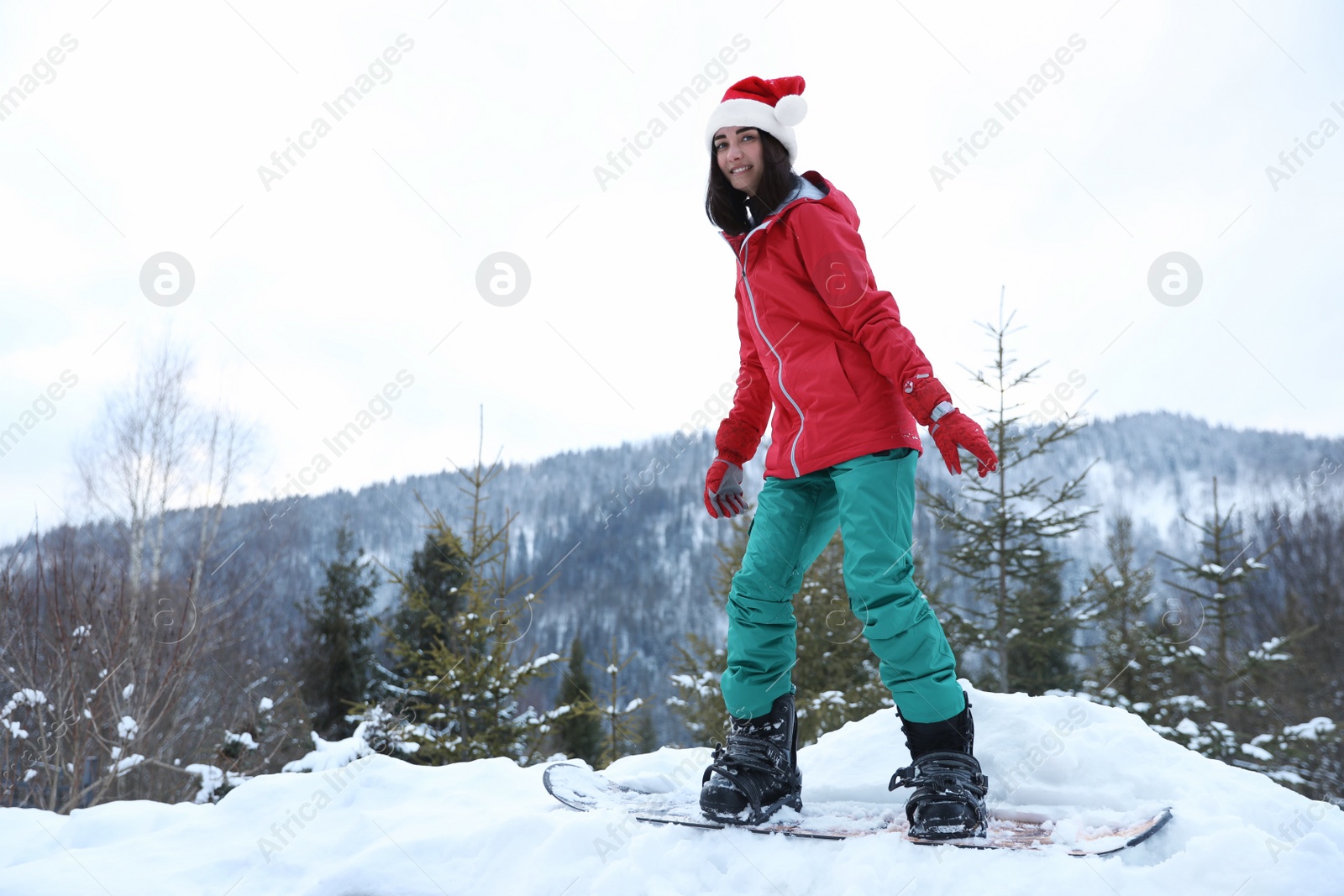 Photo of Young snowboarder wearing winter sport clothes on hill