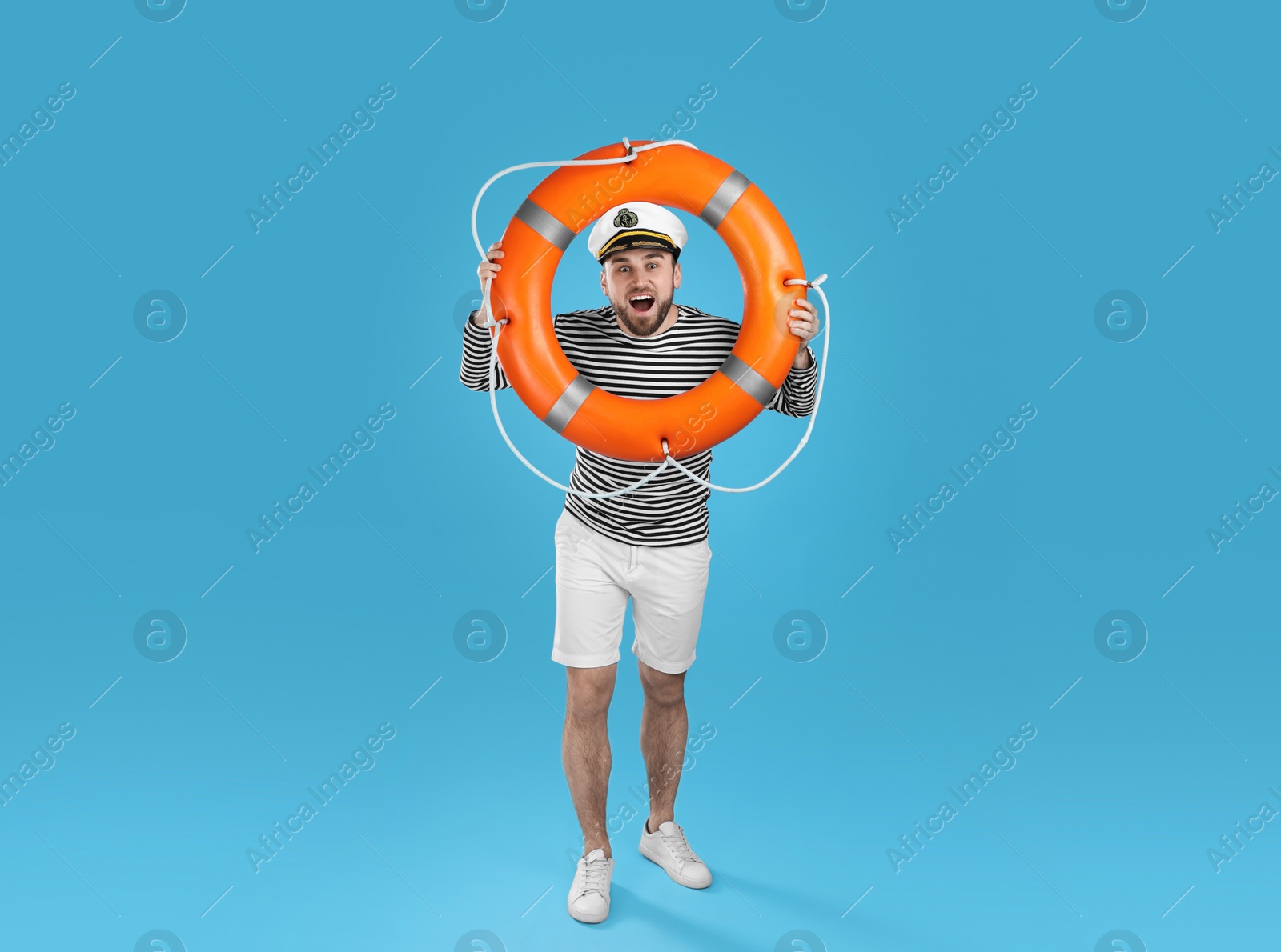 Photo of Sailor with ring buoy on light blue background