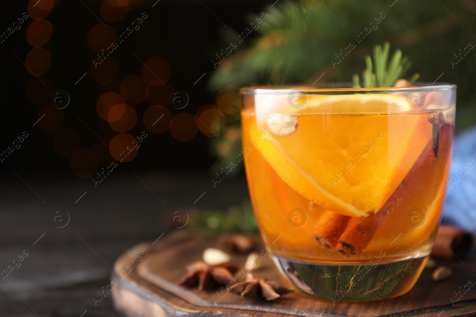 Photo of Aromatic mulled wine on wooden board. Space for text