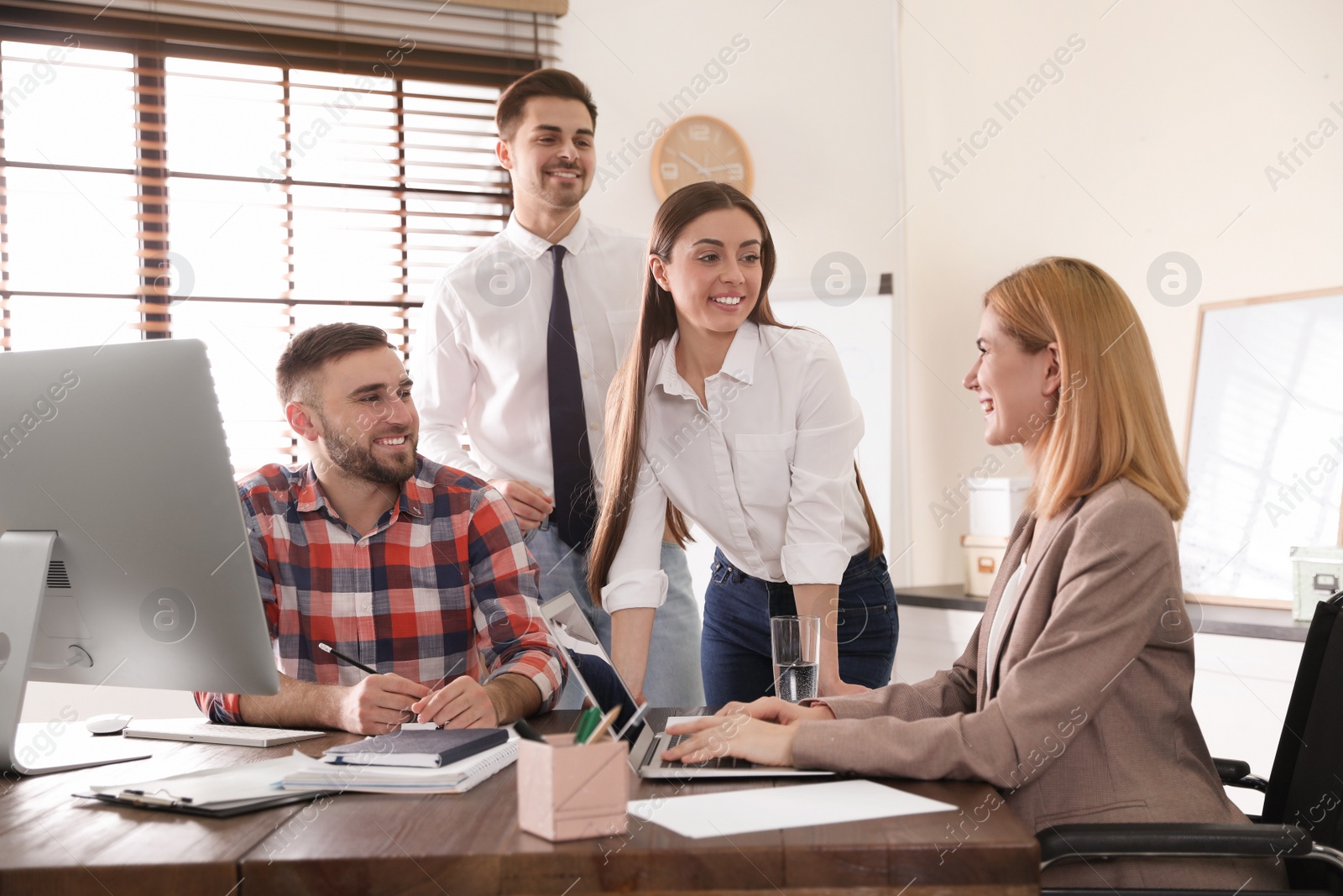 Photo of Woman in wheelchair with her colleagues at workplace