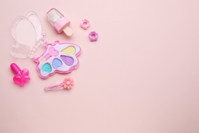 Photo of Eye shadow palette and other decorative cosmetics for kids on pink background, flat lay. Space for text