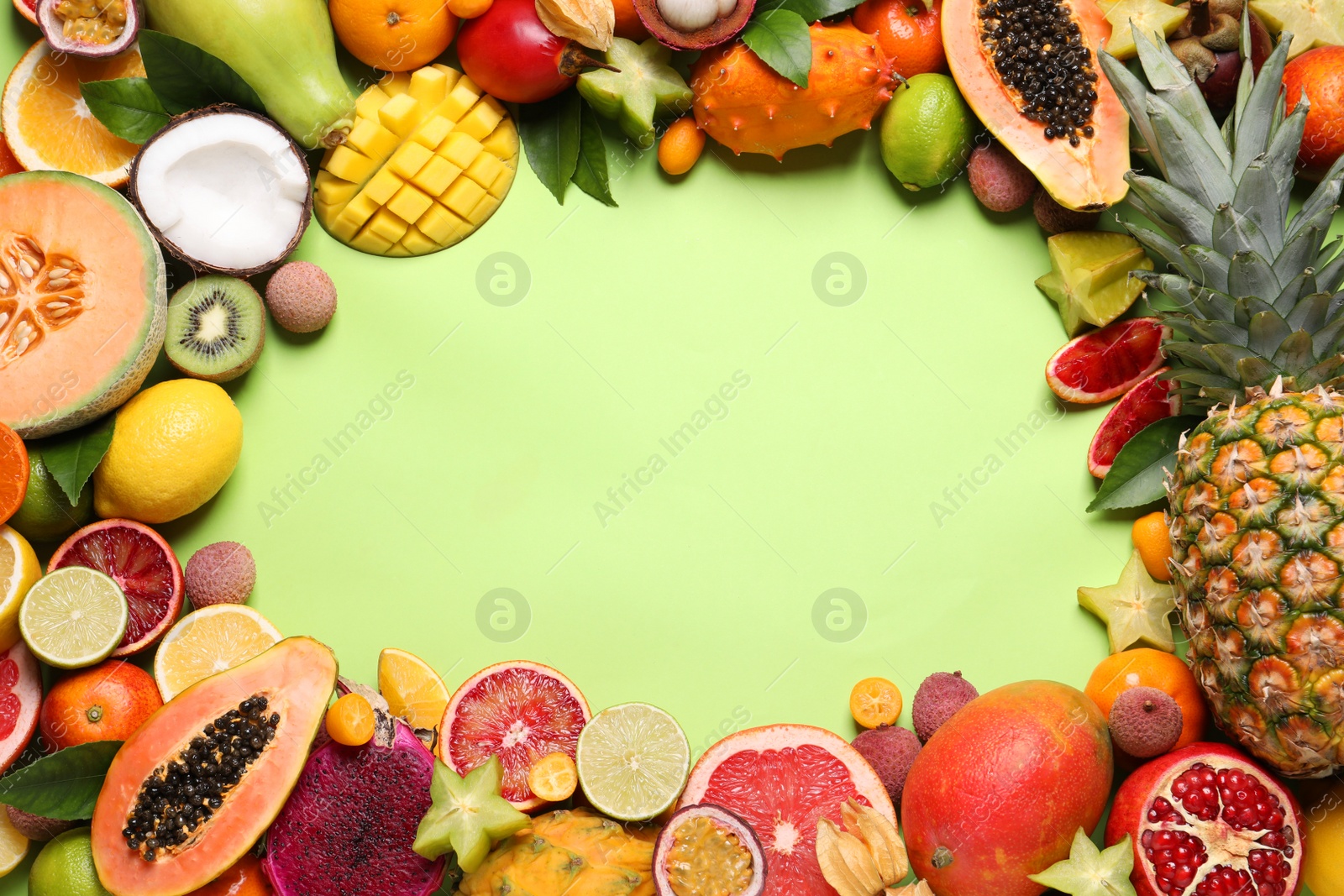 Photo of Frame of different exotic fruits on green background, flat lay. Space for text