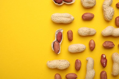 Photo of Fresh peanuts on yellow table, flat lay. Space for text