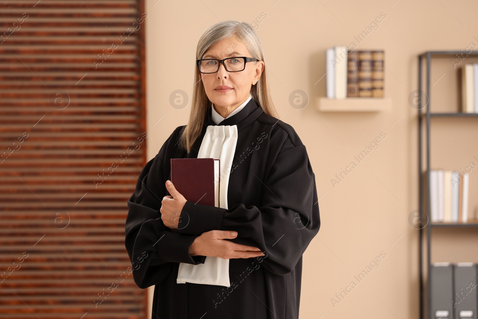 Photo of Portrait of judge in court dress with book indoors