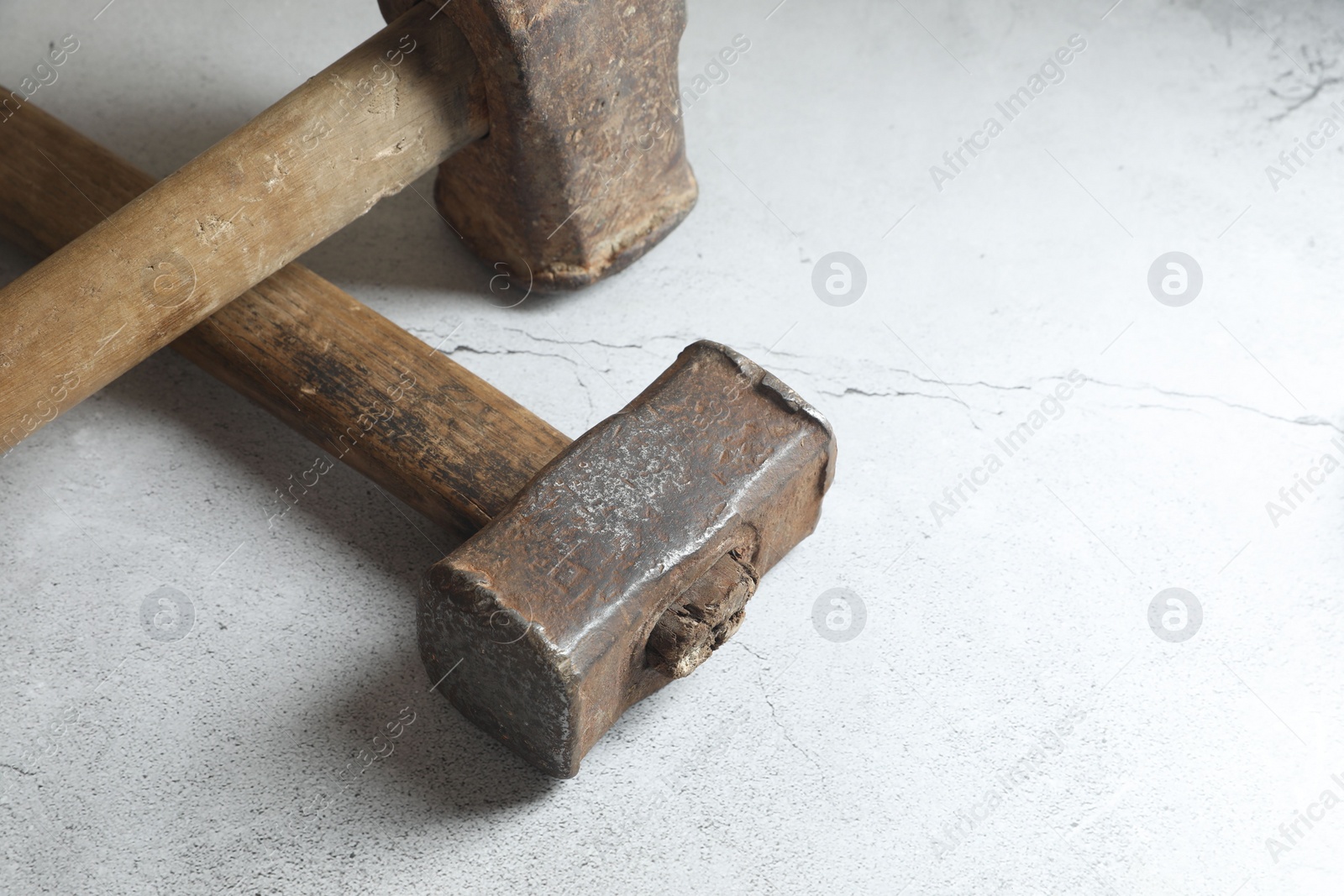 Photo of Two sledgehammers on grey background, closeup. Space for text