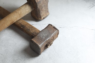 Two sledgehammers on grey background, closeup. Space for text