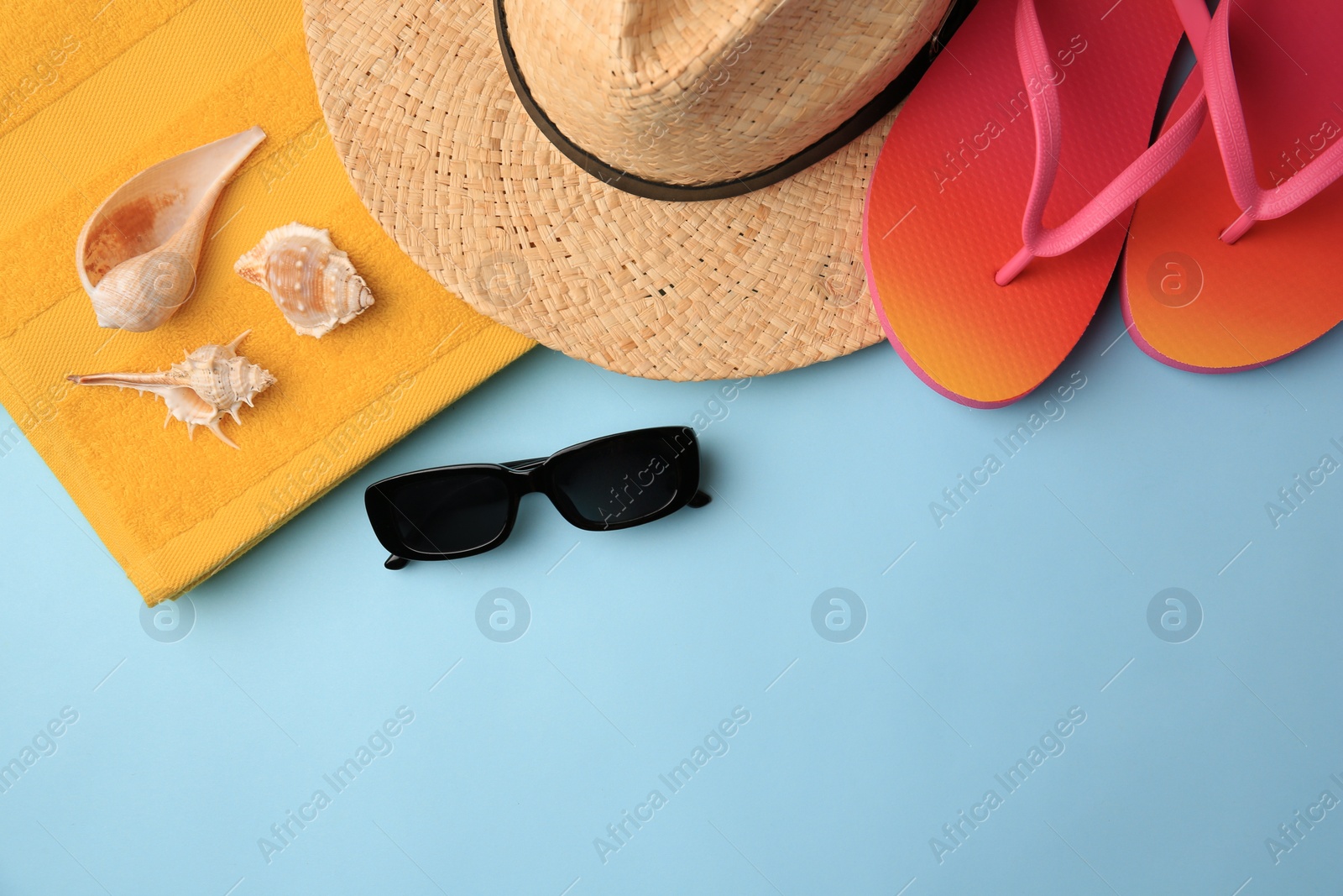 Photo of Flat lay composition with beach accessories on light blue background, space for text