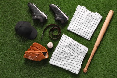 Photo of Flat lay composition with baseball equipment on artificial grass