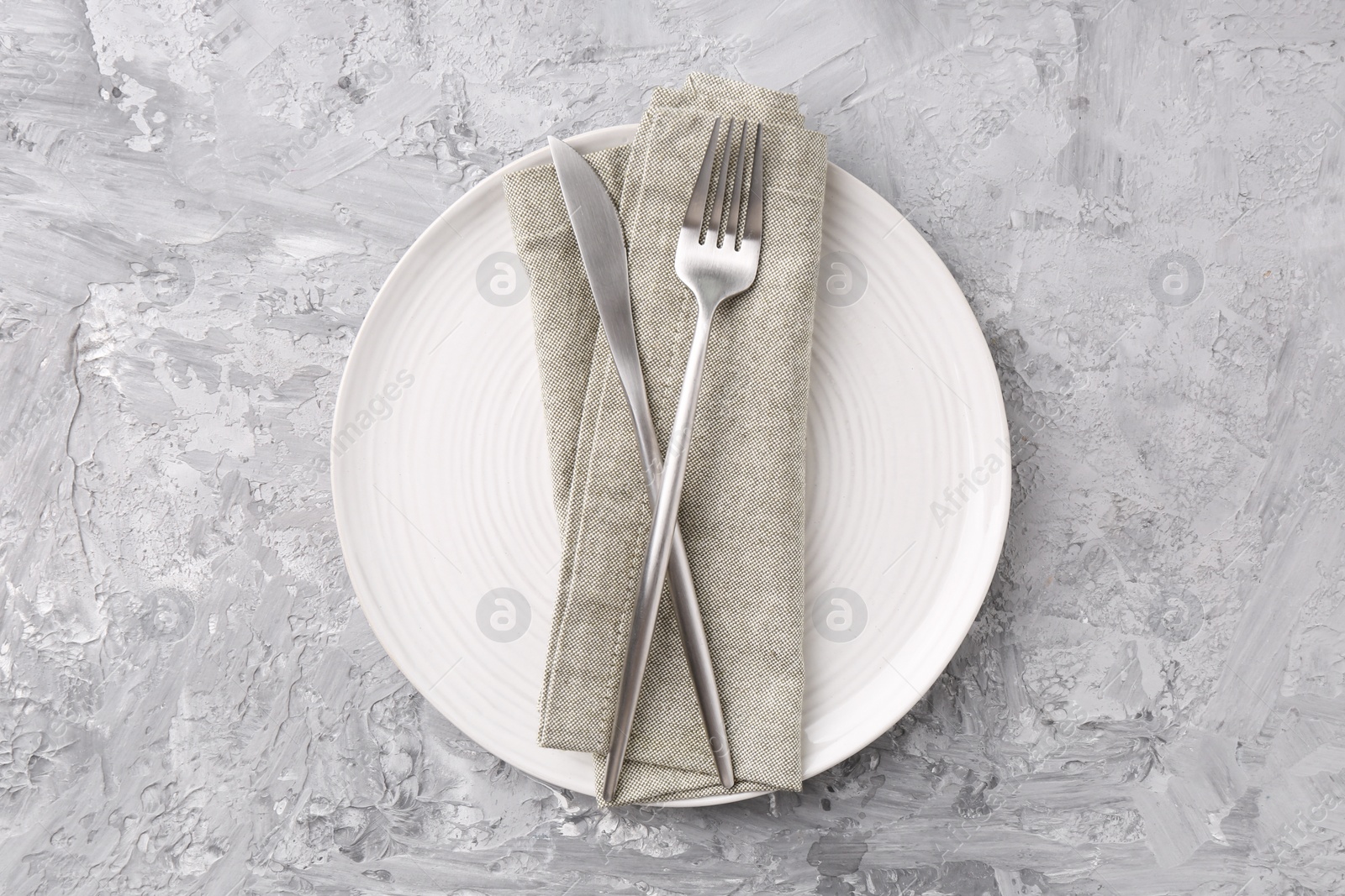 Photo of Elegant setting with silver cutlery on grey textured table, top view