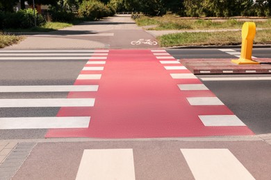 Bicycle lane with painted white sign and pedestrian crossing outdoors