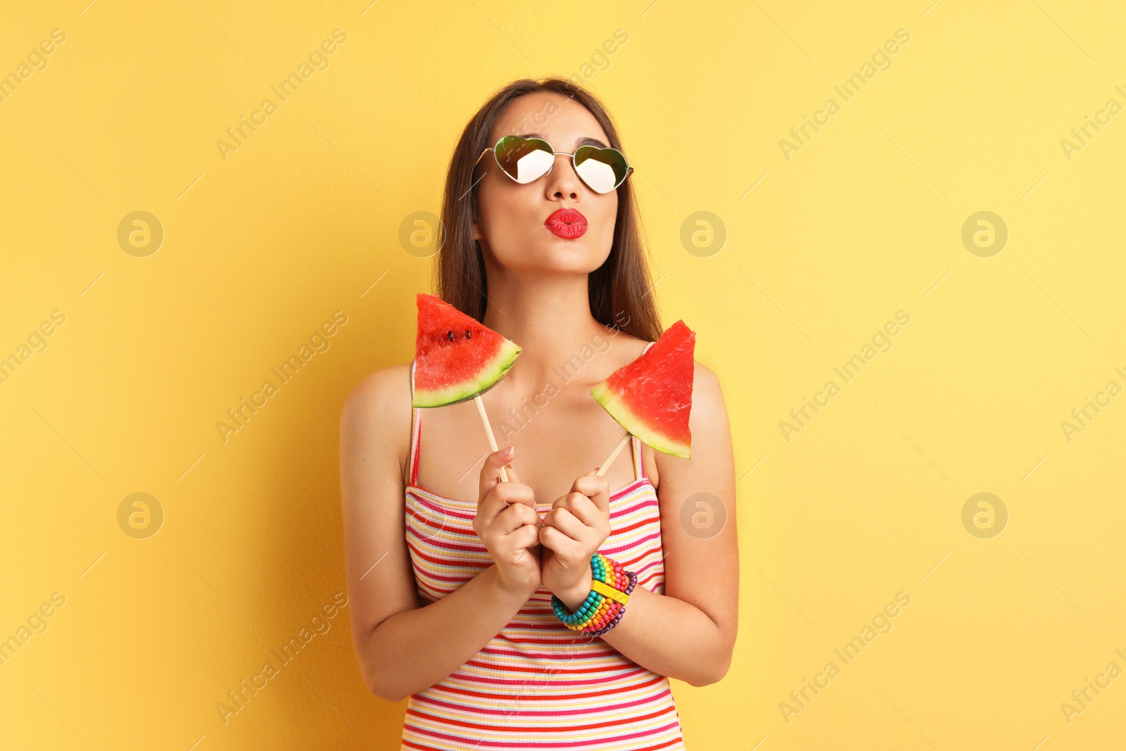 Photo of Beautiful young woman posing with watermelon on color background