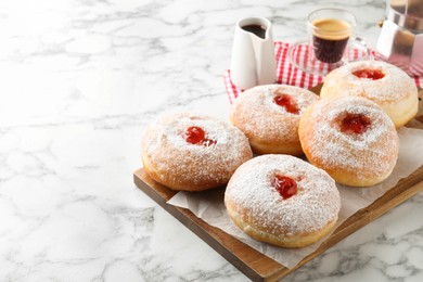 Photo of Delicious jam donuts served with coffee on white marble table. Space for text