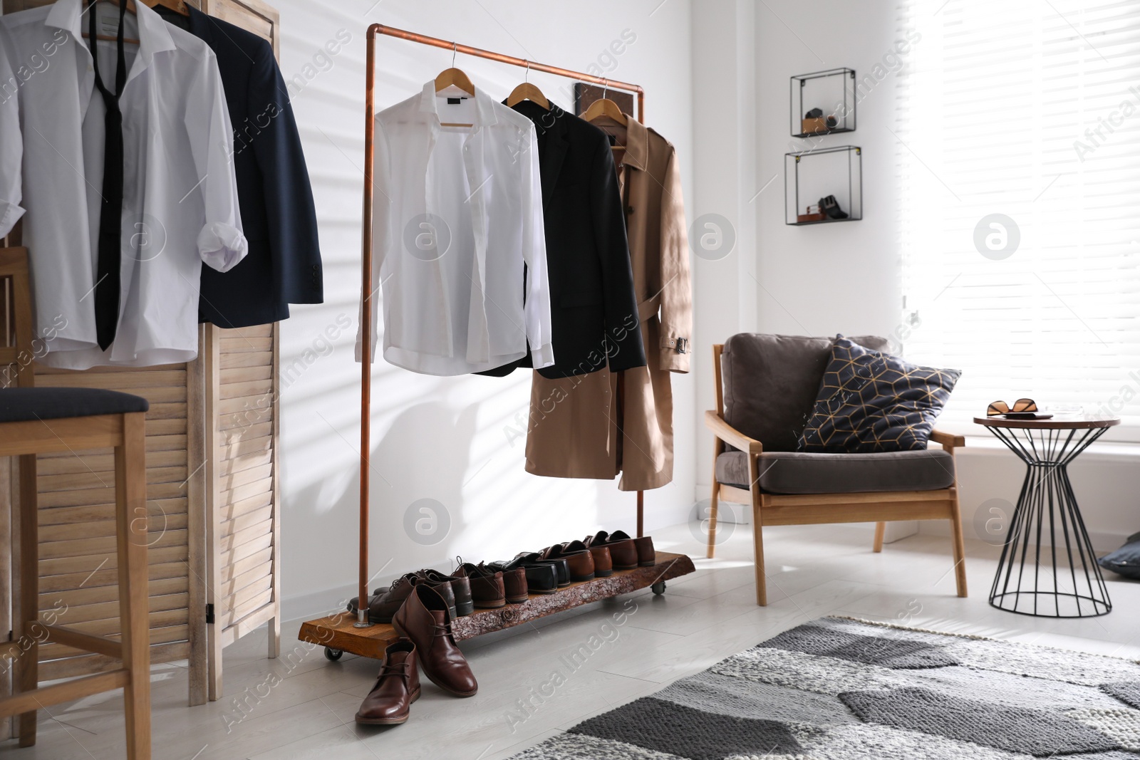 Photo of Dressing room interior with clothing rack and armchair