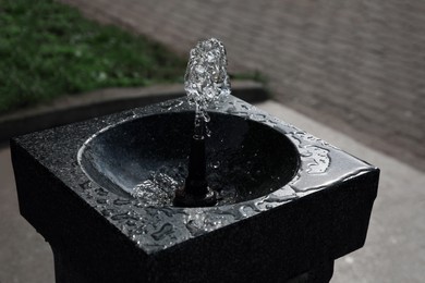 Photo of Drinking fountain with running water on city street