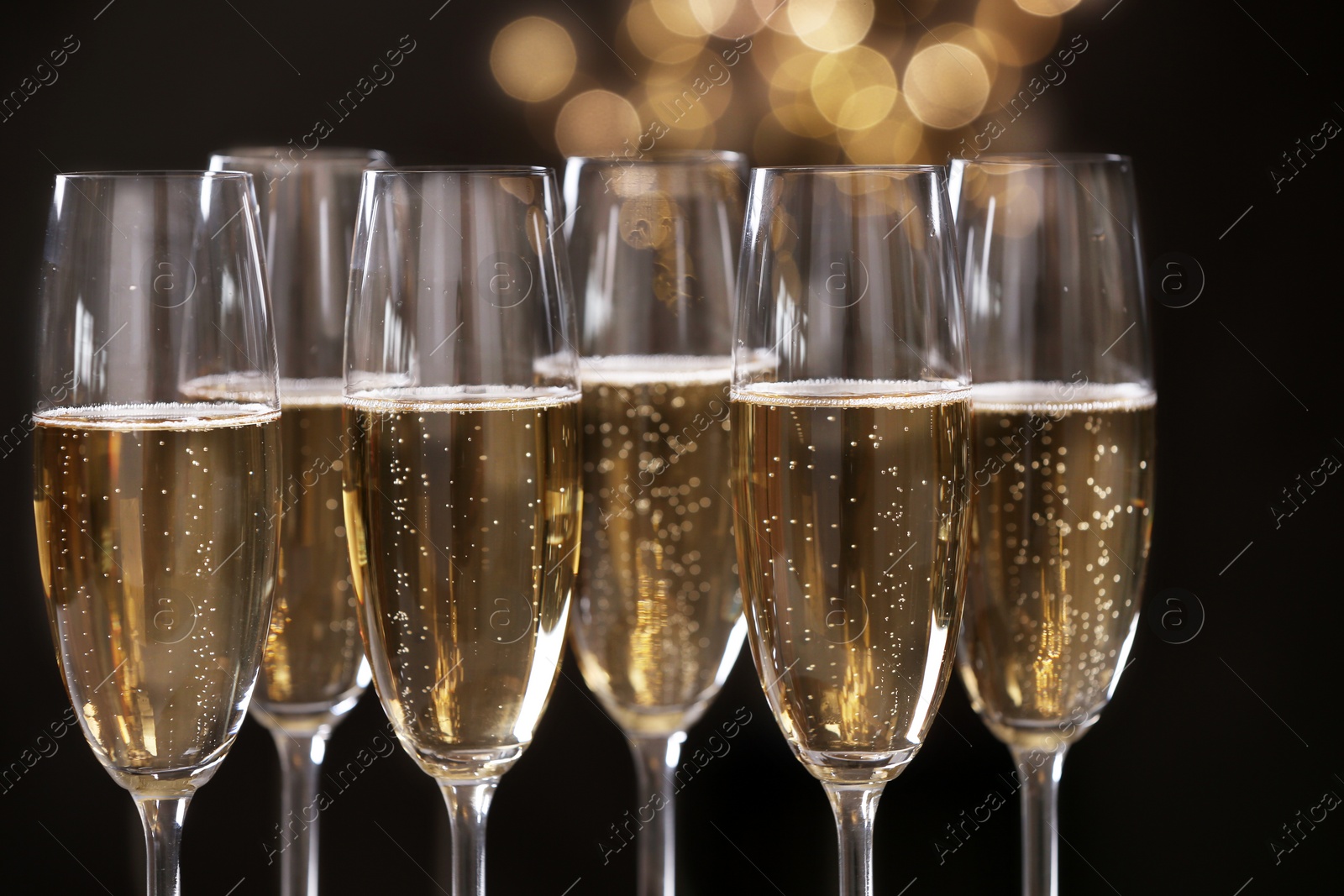 Photo of Many glasses of champagne on blurred background, closeup