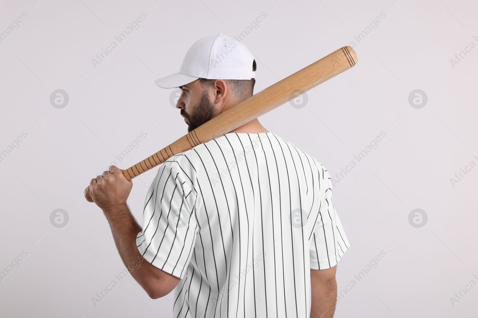 Photo of Man in stylish baseball cap holding bat on white background, back view