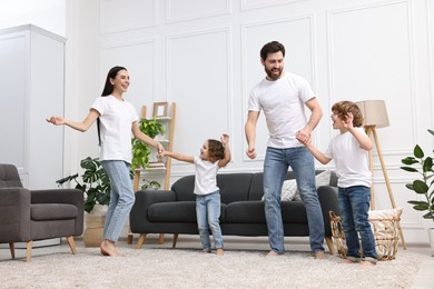 Photo of Happy family dancing in living room, low angle view