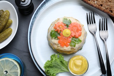 Photo of Delicious chicken aspic served on black table, flat lay