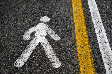 Pedestrian area sign and road lines painted on asphalt outdoors