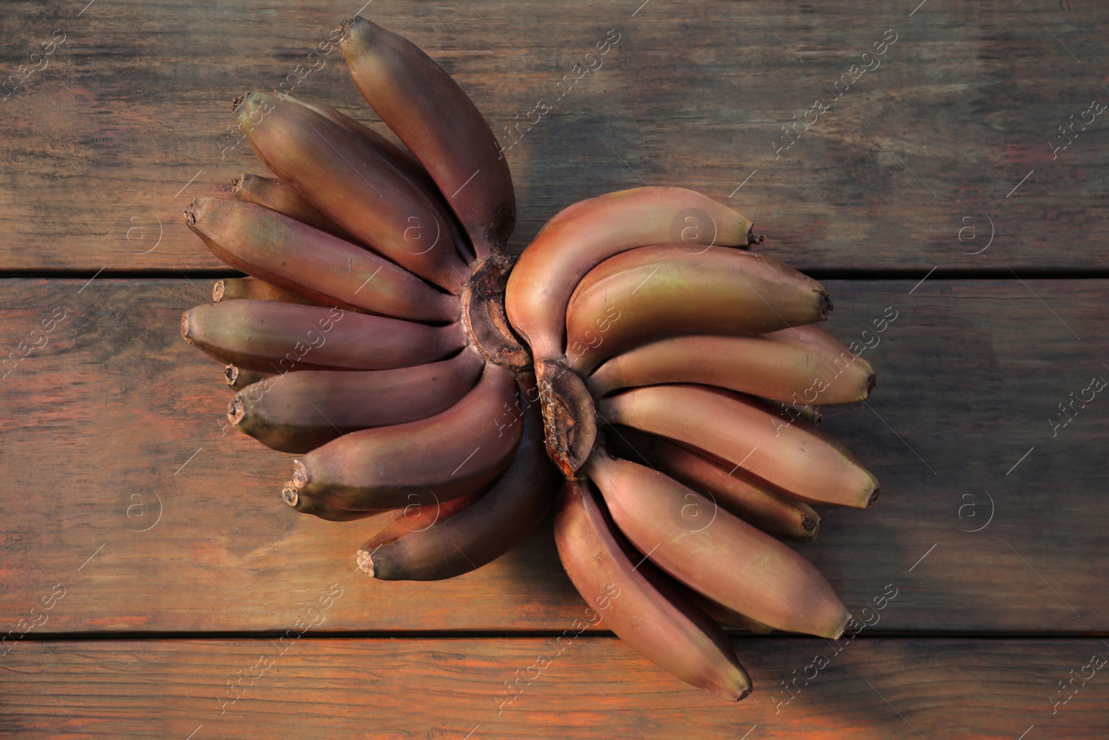 Photo of Tasty purple bananas on wooden table, flat lay