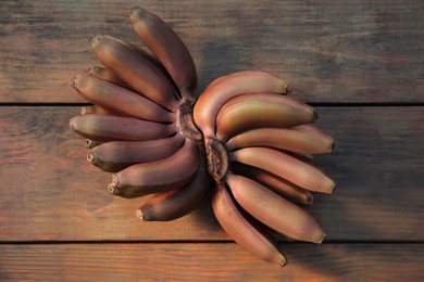 Tasty purple bananas on wooden table, flat lay