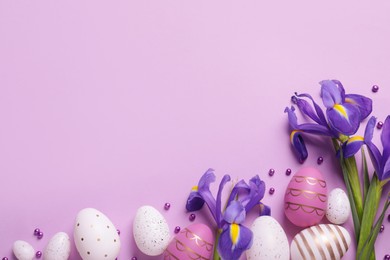 Photo of Flat lay composition with festively decorated Easter eggs and iris flowers on violet background. Space for text