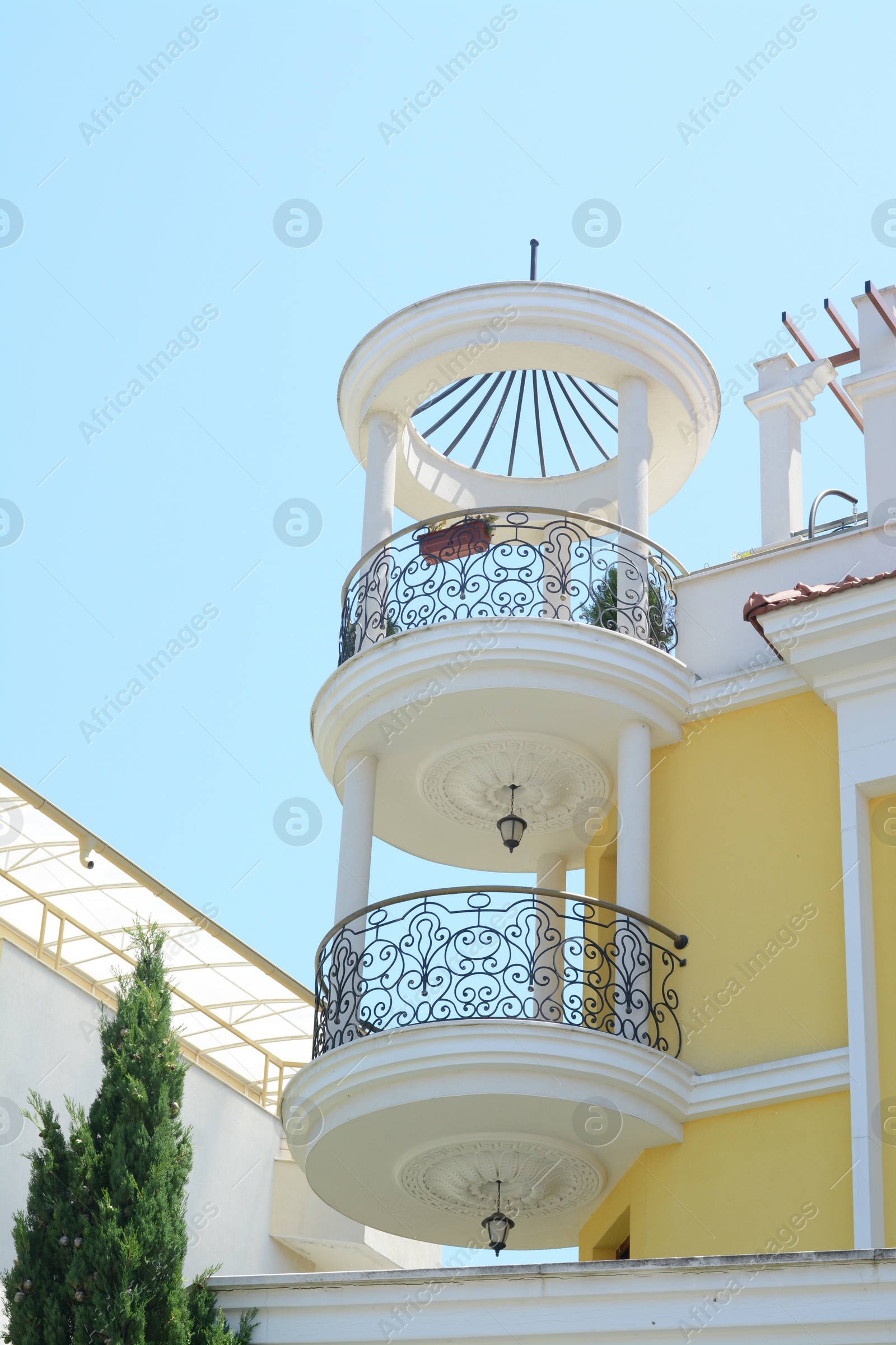 Photo of Exterior of beautiful building with balconies against blue sky, low angle view